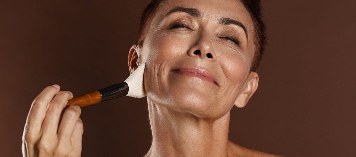 senior-shirtless-woman-smiling-while-using-powder-2023-11-27-05-30-53-utc